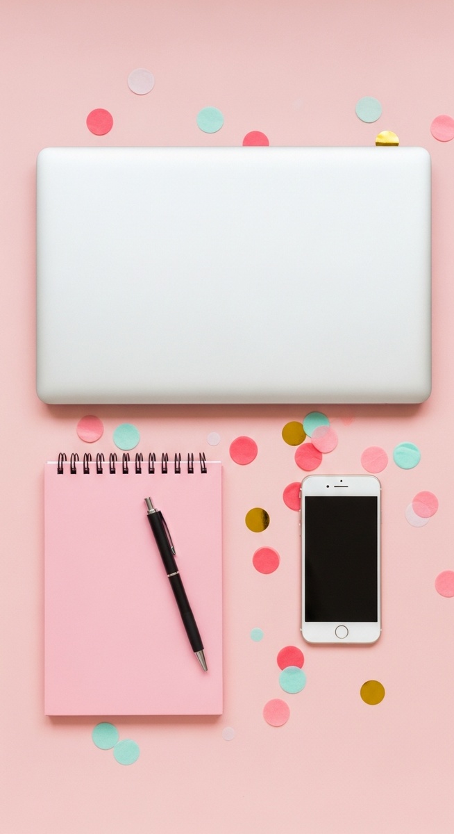 pink flatlay with laptop, notebook, and phone