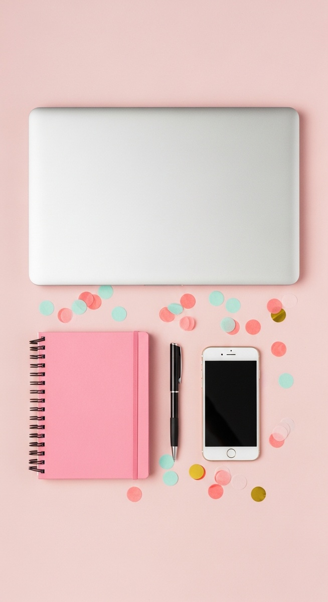 pink flatlay with laptop, notebook, and phone