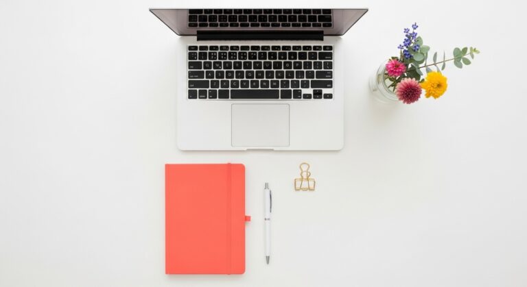 a flatlay with laptop and other items on a white surface to make money