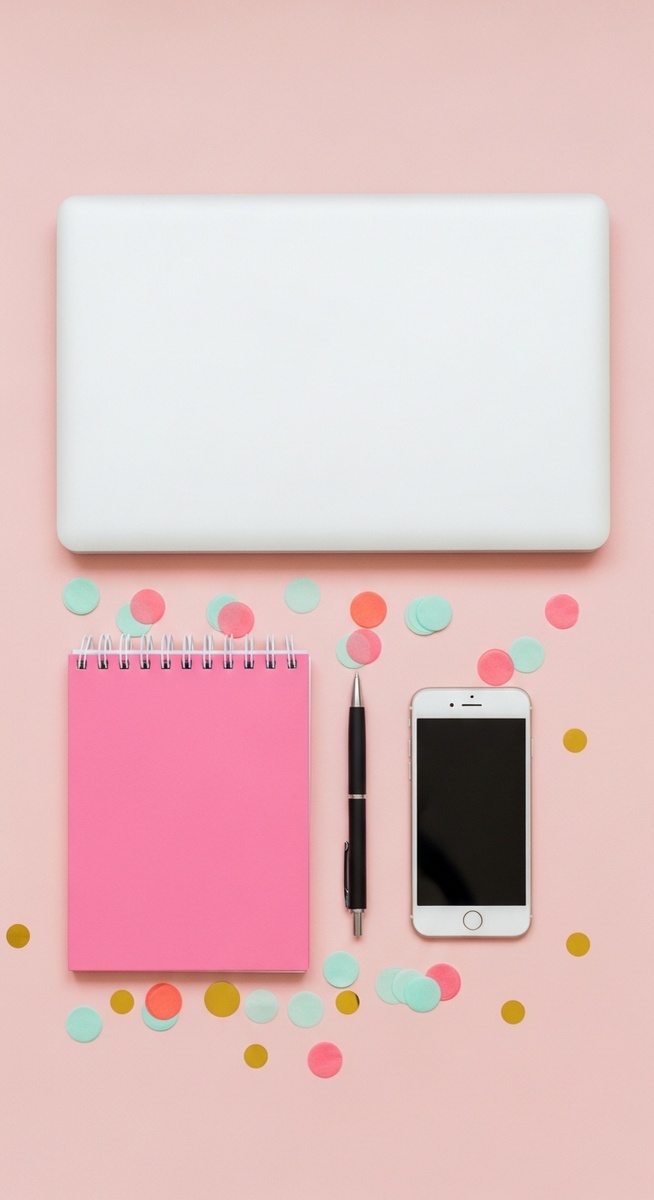 pink flatlay with laptop, notebook, and phone