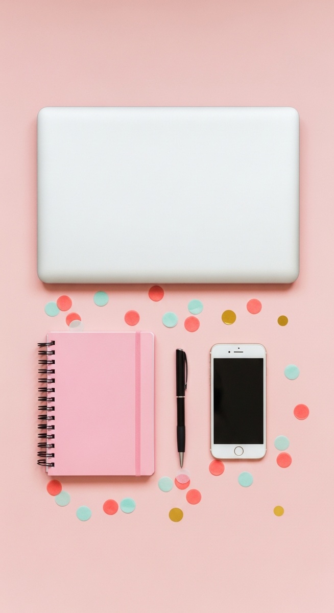 pink flatlay with laptop, notebook, and phone