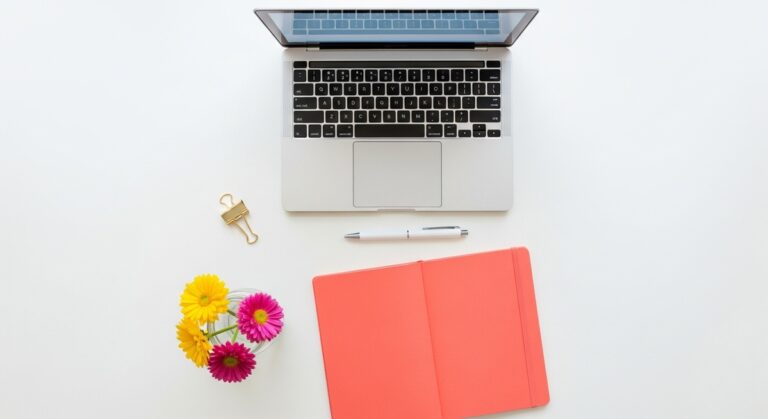 flatlay with laptop and other items on a white surface