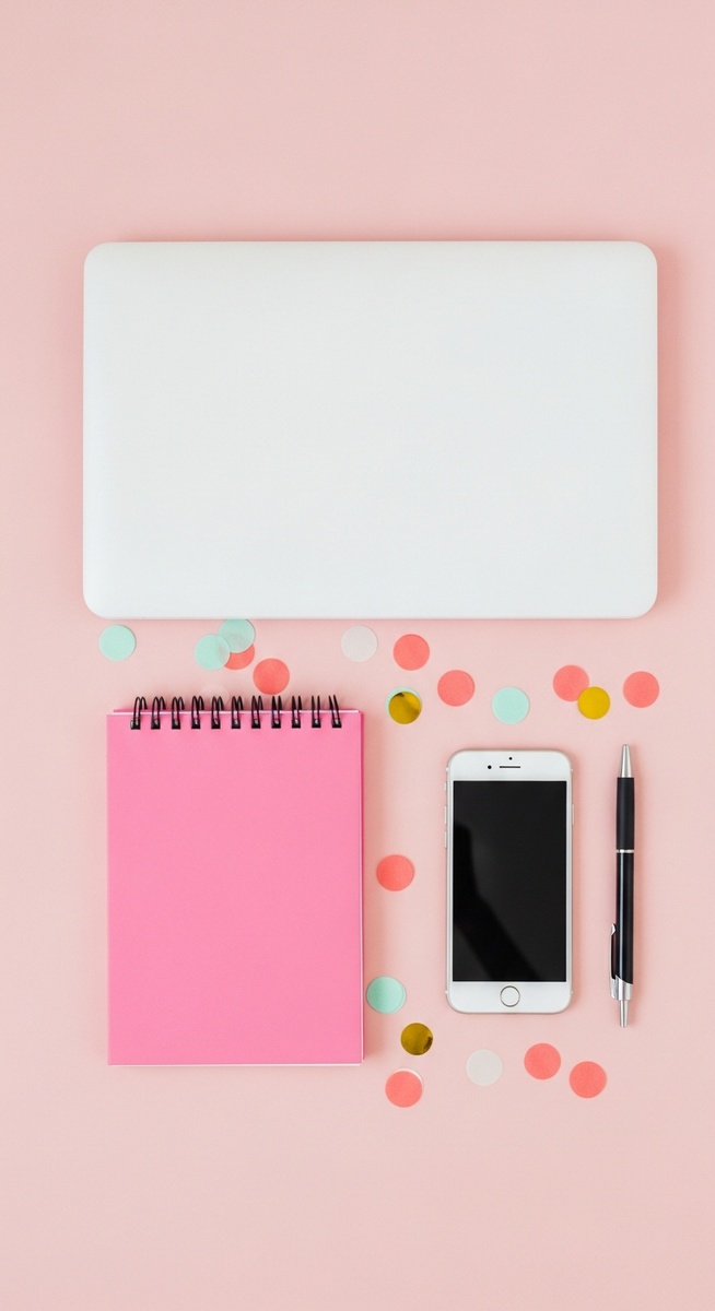 a pink flatlay with laptop, notebook, and phone to save $10,000