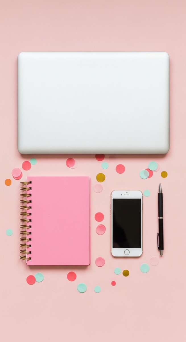 pink flatlay with laptop, notebook, and phone