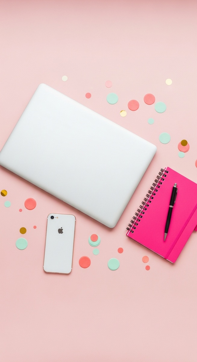 pink flatlay with laptop, notebook, and phone