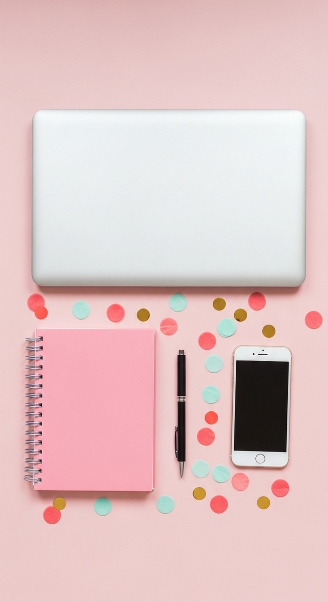 pink flatlay with laptop, notebook, and phone